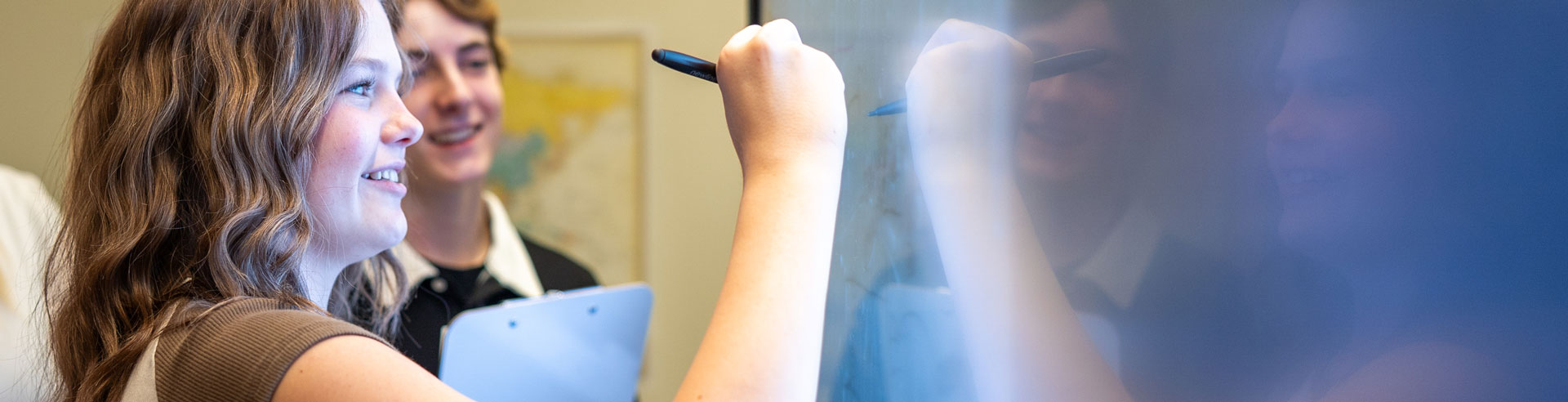 students writing on a whiteboard